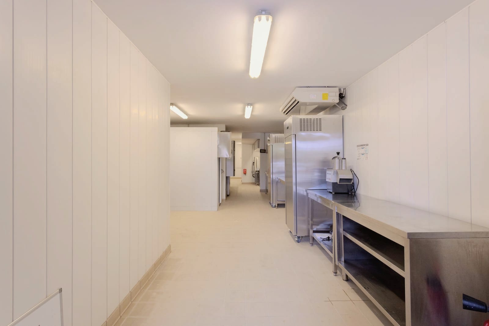 Vue d’ensemble du laboratoire — couloir de production, inox et chambres froides